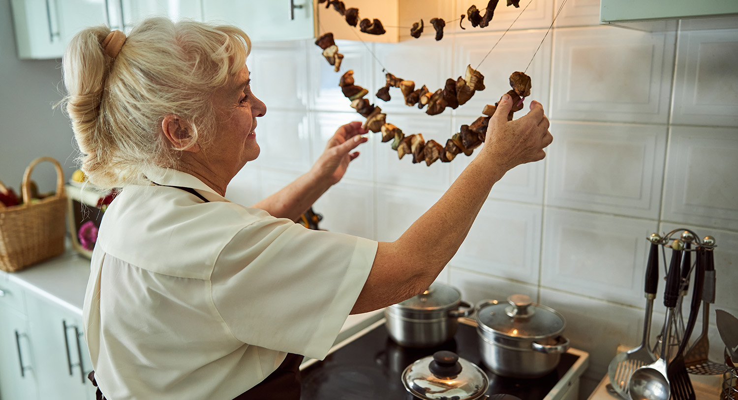 suszenie-grzyb&oacute;w-kobieta-starsza-suszy-grzyby-na-nitce-suszenie-grzyb&oacute;w-na-nitce