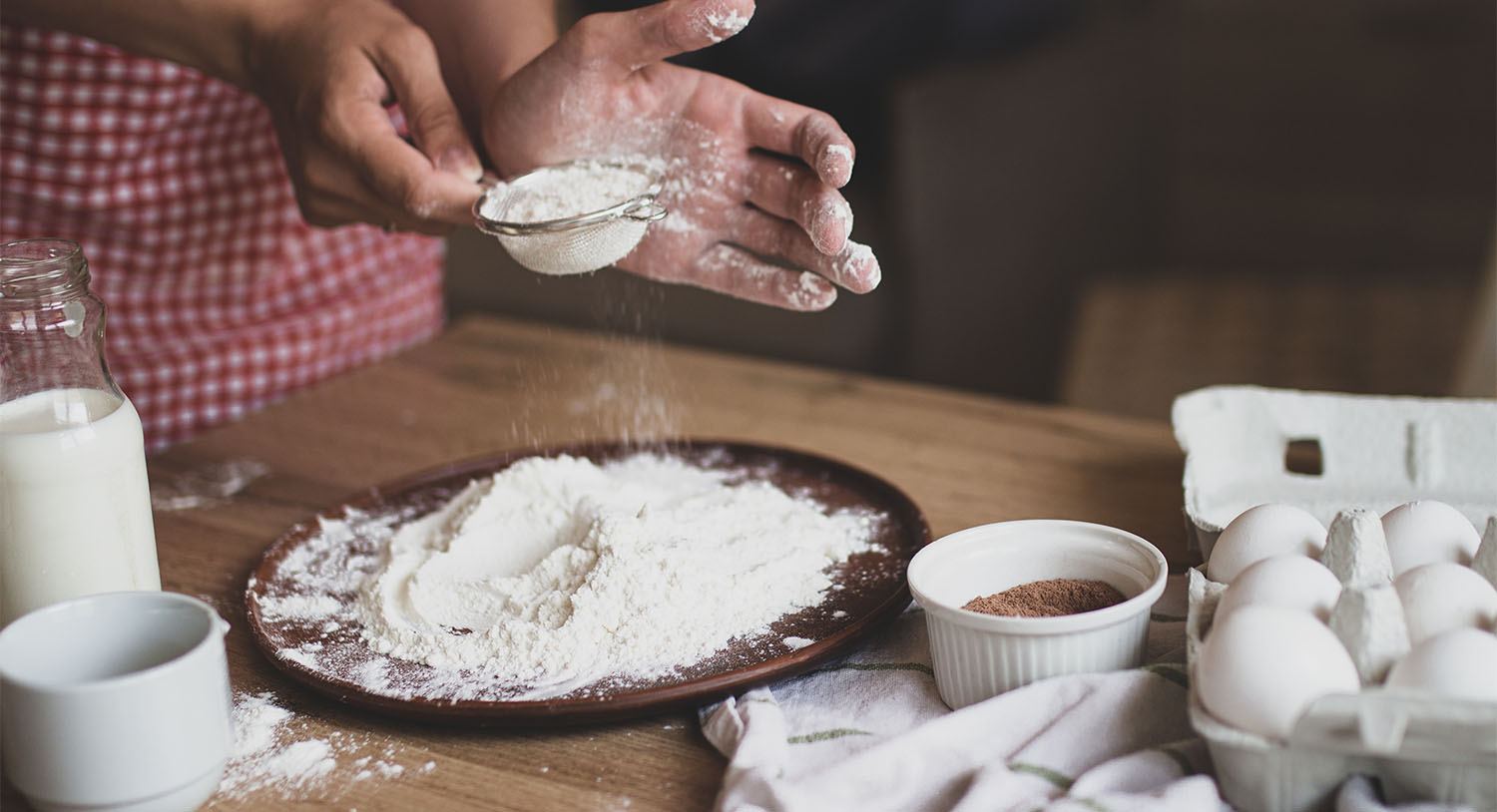 kobieta-przebiera-mąkę-przysypuje-mąkę-przez-sitko-przygotowywuje-produkty-do-stworzenia-ciasta-na-placek-na-tort