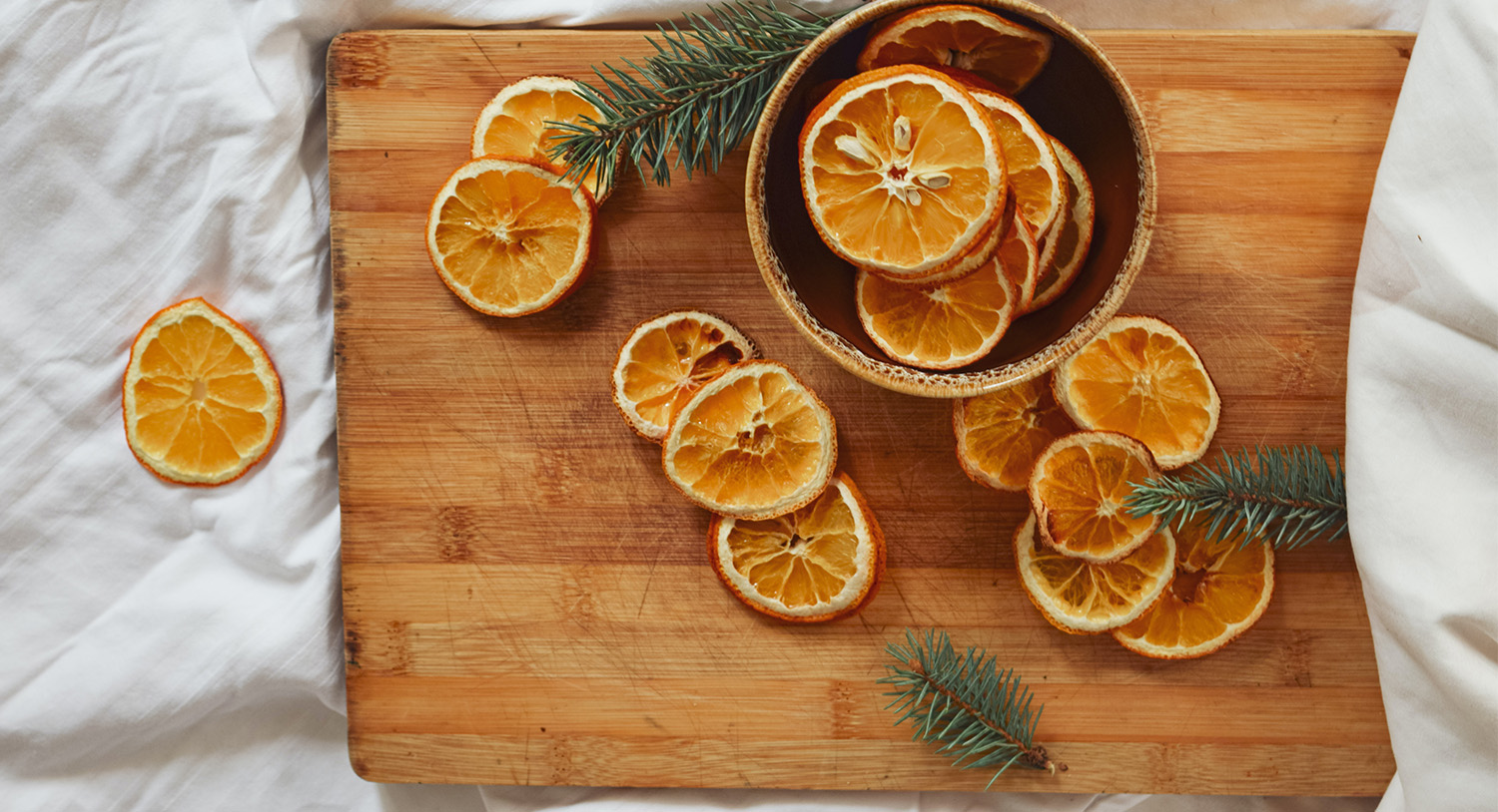 drewniana-taca-suszone-owoce-suszone-pomarańcze-aranżacja-biała-pościel