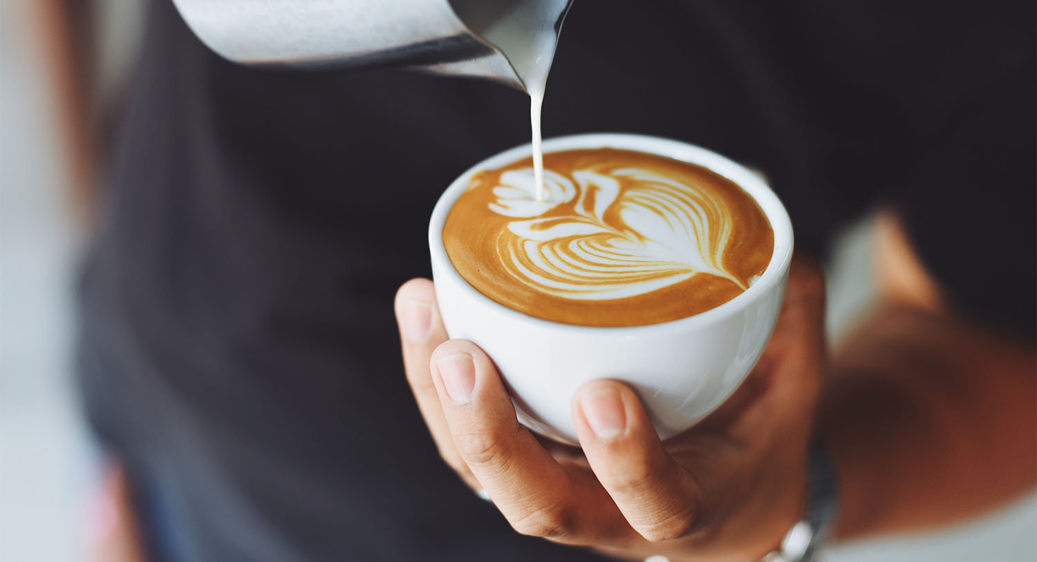 barista-tworzy-kawę-cappuccino-latte-polewa-spienione-mleko-najdroższa-kawa-świata-cena-podróże-black-ivory-coffee-kopi-luwak